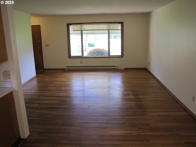 empty room with dark hardwood / wood-style flooring and baseboard heating