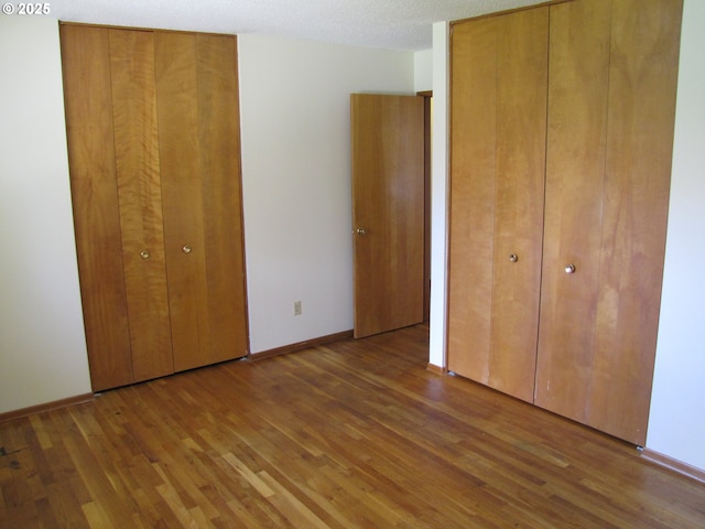 unfurnished bedroom featuring a textured ceiling and dark wood-type flooring