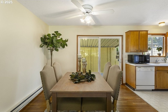 12395 SE Main St, Portland, OR 97233 - dining space with a baseboard radiator, ceiling fan, light wood finished floors, and a textured ceiling