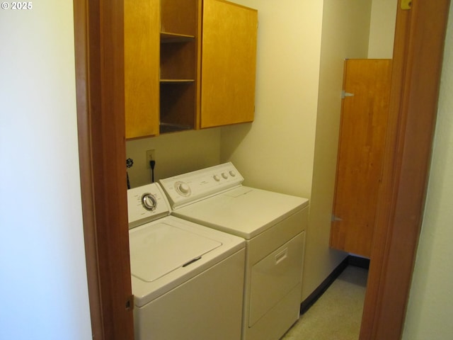 washroom with cabinets and washer and dryer