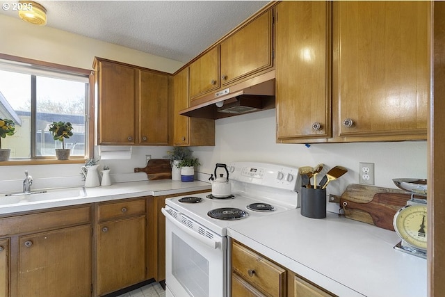 12395 SE Main St, Portland, OR 97233 - kitchen featuring white electric stove, under cabinet range hood, brown cabinetry, light countertops, and a textured ceiling