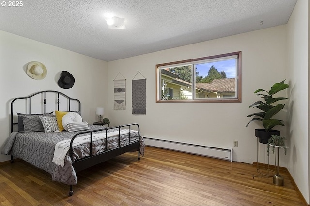 12395 SE Main St, Portland, OR 97233 - bedroom with a baseboard heating unit, light wood-type flooring, and a textured ceiling