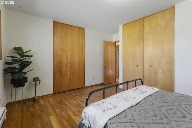 12395 SE Main St, Portland, OR 97233 - bedroom featuring hardwood / wood-style floors, two closets, and baseboard heating