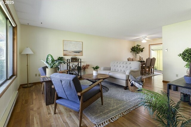 12395 SE Main St, Portland, OR 97233 - living room featuring a baseboard heating unit, wood finished floors, and ceiling fan