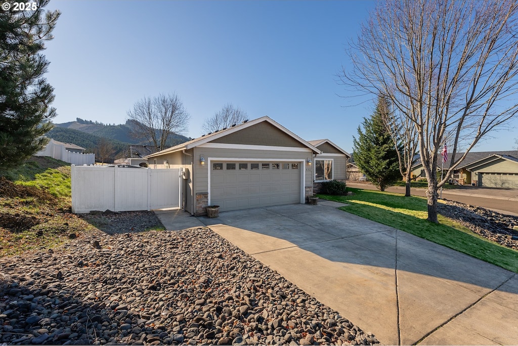 ranch-style house featuring a garage and a mountain view