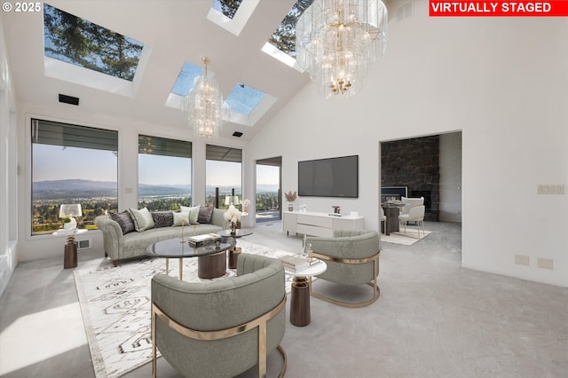 carpeted living area featuring a skylight, a chandelier, a towering ceiling, and a fireplace