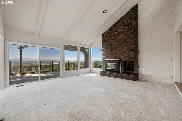 unfurnished living room with high vaulted ceiling, beamed ceiling, carpet flooring, plenty of natural light, and a stone fireplace