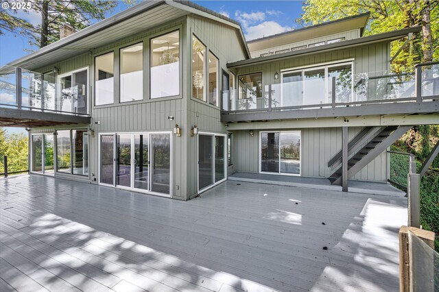 rear view of house with a sunroom and a wooden deck