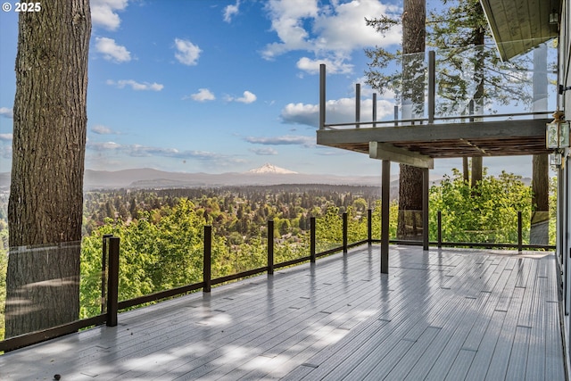 wooden deck with a mountain view and a view of trees