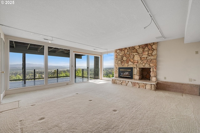 unfurnished living room featuring carpet, a fireplace, and a textured ceiling