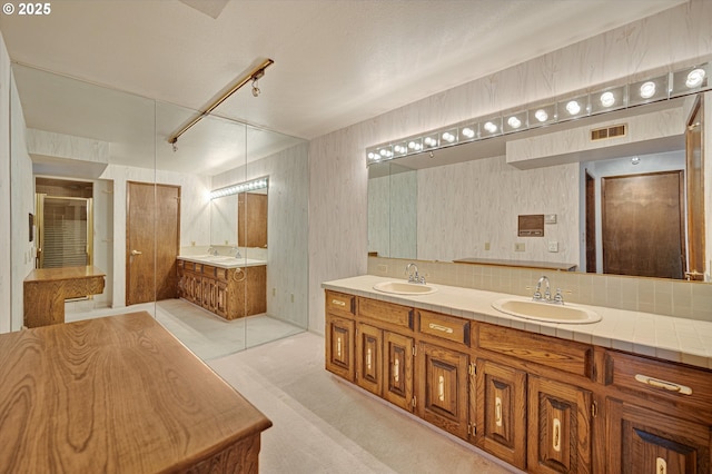bathroom with double vanity, a shower with door, wallpapered walls, and a tub