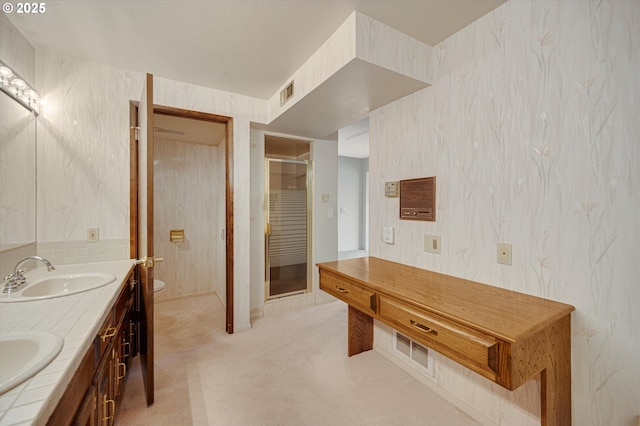 bathroom with wallpapered walls, toilet, and double vanity