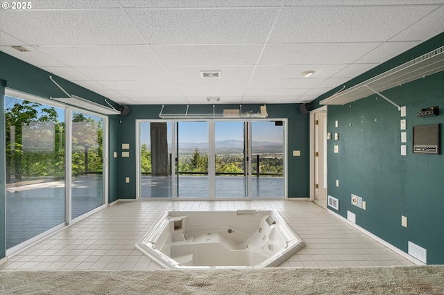 kitchen featuring tile patterned floors, a drop ceiling, a mountain view, and baseboards