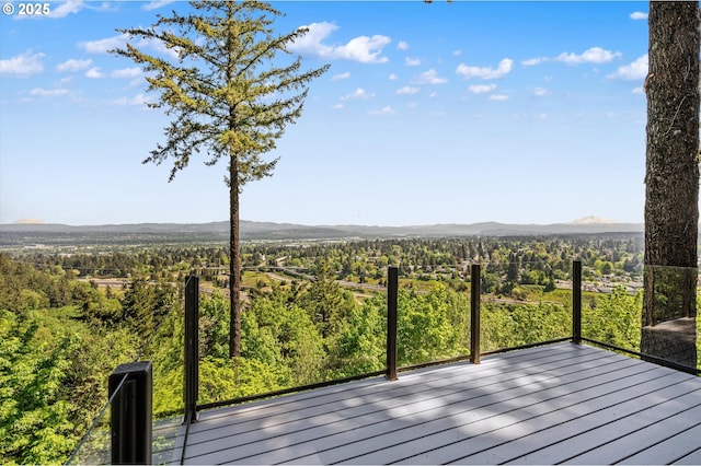wooden deck with a view of trees and a mountain view