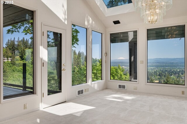 unfurnished sunroom with a skylight, carpet flooring, and a chandelier