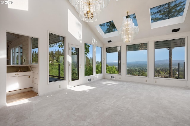 unfurnished sunroom with a chandelier and a skylight