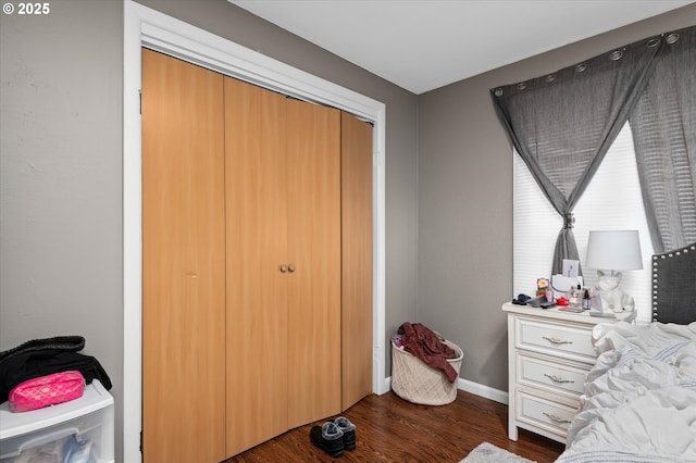 bedroom with dark wood-type flooring and a closet