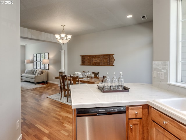 11656 SW Auklet Loop, Beaverton, OR 97007 - kitchen featuring dishwasher, a peninsula, open floor plan, light wood-style floors, and a chandelier