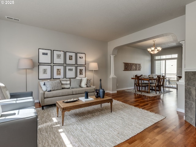 11656 SW Auklet Loop, Beaverton, OR 97007 - living room featuring arched walkways, a chandelier, wood finished floors, and ornate columns