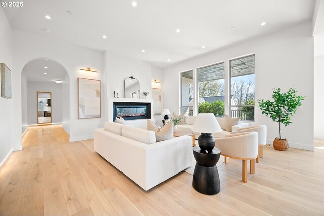 5100 S St, Washougal, WA 98671 - living area featuring a glass covered fireplace, light wood-style floors, baseboards, recessed lighting, and arched walkways