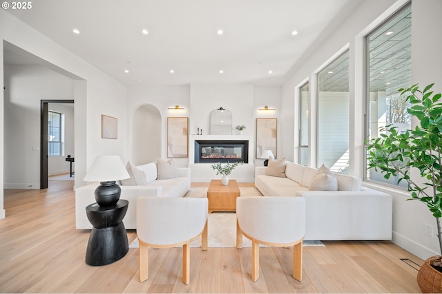 5100 S St, Washougal, WA 98671 - living area featuring arched walkways, baseboards, a glass covered fireplace, recessed lighting, and light wood-style flooring