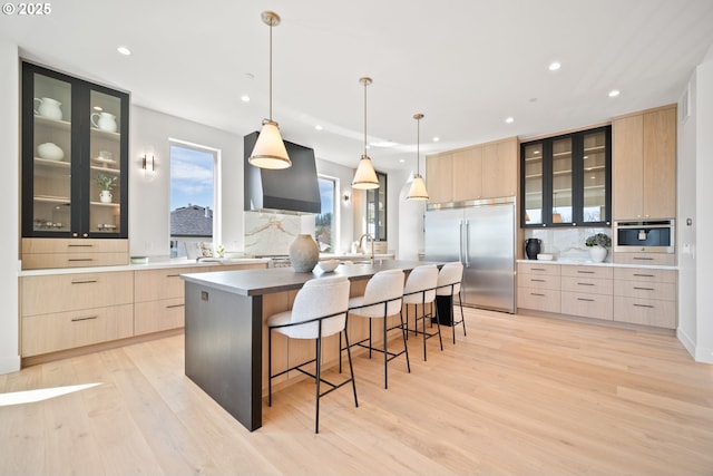 5100 S St, Washougal, WA 98671 - kitchen featuring light brown cabinets, modern cabinets, wall chimney range hood, appliances with stainless steel finishes, and backsplash