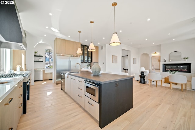 5100 S St, Washougal, WA 98671 - kitchen featuring light wood-style floors, arched walkways, modern cabinets, and wall chimney range hood