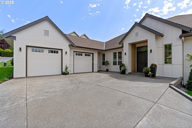 5100 S St, Washougal, WA 98671 - view of front facade featuring an attached garage, a shingled roof, board and batten siding, and driveway