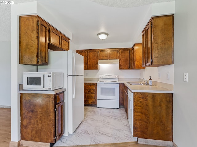 619 SE 121st Ave Unit 23, Vancouver, WA 98683 - kitchen featuring white appliances, a sink, under cabinet range hood, light countertops, and brown cabinetry