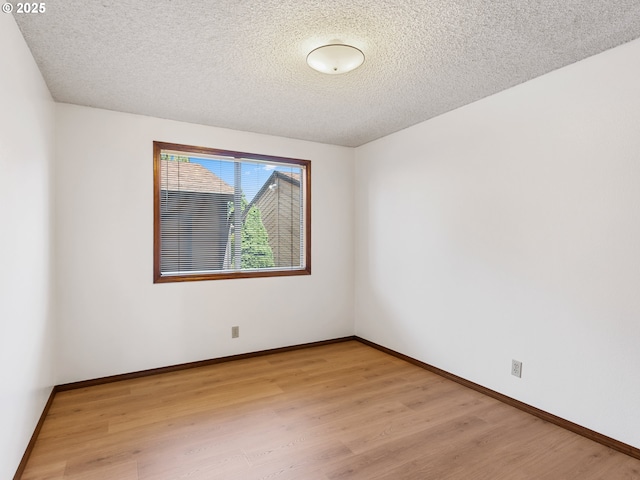 619 SE 121st Ave Unit 23, Vancouver, WA 98683 - spare room featuring light wood finished floors, a textured ceiling, and baseboards