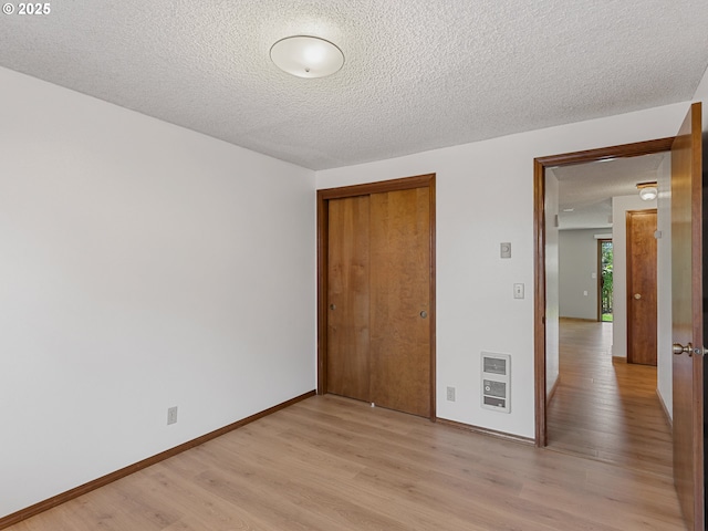 619 SE 121st Ave Unit 23, Vancouver, WA 98683 - spare room featuring heating unit, light wood-style flooring, a textured ceiling, and baseboards