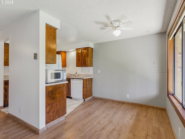 619 SE 121st Ave Unit 23, Vancouver, WA 98683 - kitchen with white appliances, a ceiling fan, light wood-type flooring, brown cabinetry, and a textured ceiling