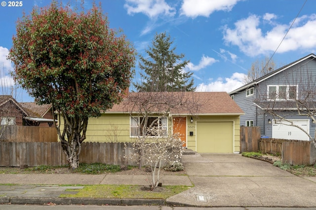 view of front of home with an attached garage, driveway, roof with shingles, and fence