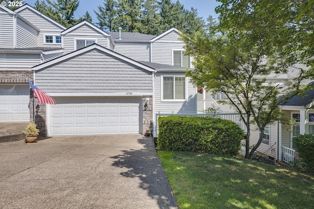 15760 SW Peachtree Dr, Portland, OR 97224 - view of front of house with driveway, a front lawn, stone siding, an attached garage, and a shingled roof