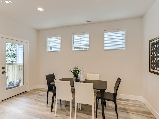 dining space featuring light wood finished floors, baseboards, visible vents, and recessed lighting