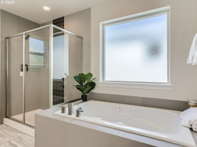 full bathroom featuring a stall shower, marble finish floor, and a garden tub