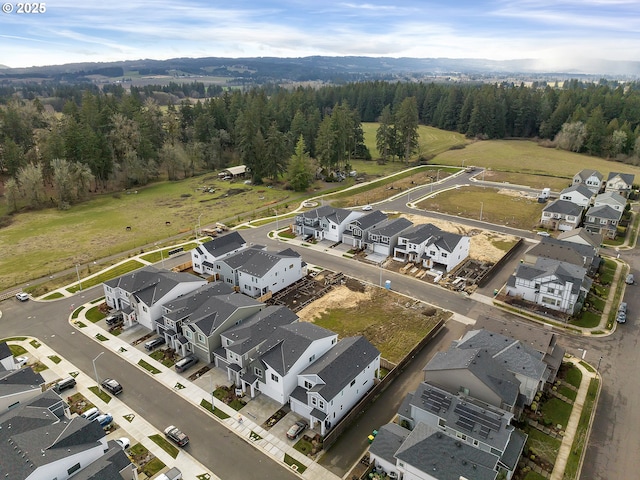 drone / aerial view featuring a residential view and a wooded view