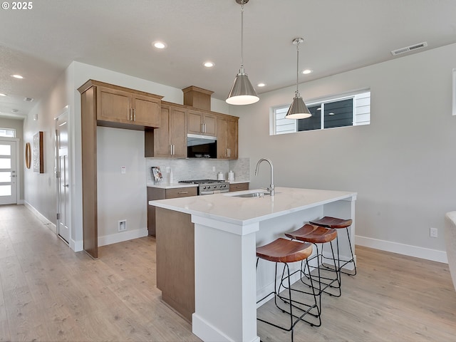 13847 SW Sabrina Ave, Tigard, OR 97140 - kitchen featuring light wood-style floors, decorative backsplash, healthy amount of natural light, light countertops, and recessed lighting