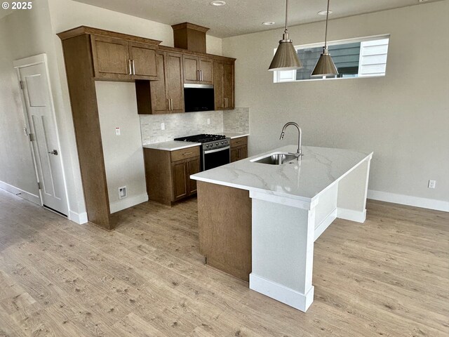 13847 SW Sabrina Ave, Tigard, OR 97140 - kitchen featuring stainless steel range with gas cooktop, a sink, light wood-style floors, backsplash, and baseboards
