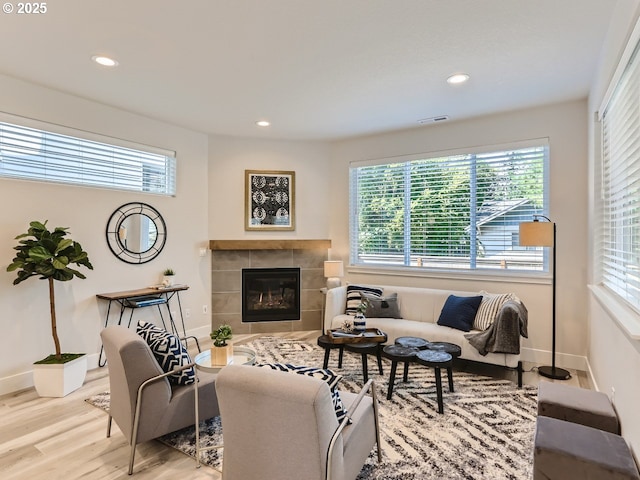 living area featuring recessed lighting, visible vents, wood finished floors, and a tile fireplace