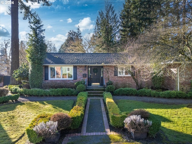 view of front of home with brick siding and a front lawn