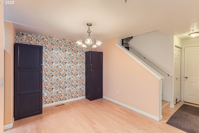 10793 SW Canterbury Ln Unit 101, Portland, OR 97224 - unfurnished dining area featuring wallpapered walls, light wood-type flooring, and a chandelier