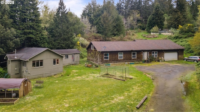 view of front of house with a garage, aphalt driveway, and a front yard