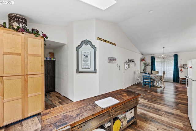 interior space with wood finished floors and lofted ceiling with skylight