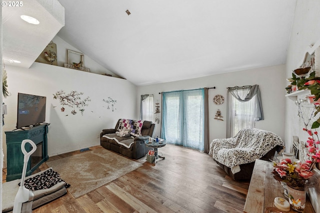 living area with wood finished floors and high vaulted ceiling
