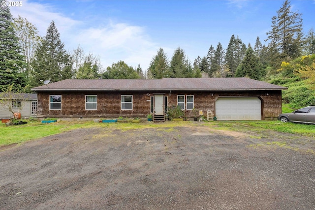 ranch-style home with an attached garage and aphalt driveway