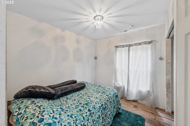 bedroom with visible vents and wood finished floors