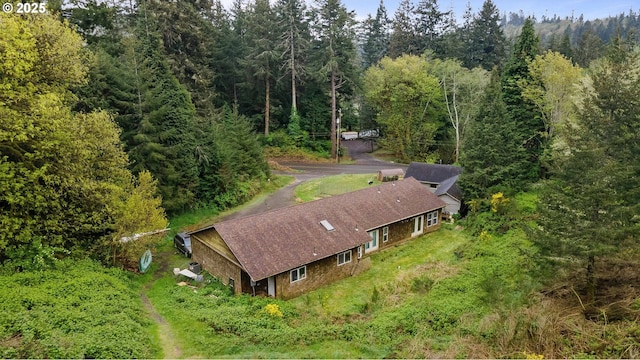 bird's eye view with a wooded view