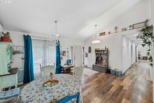 dining room with an inviting chandelier, wood finished floors, and vaulted ceiling