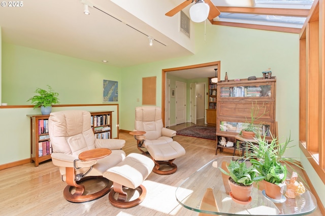 sitting room with ceiling fan, visible vents, wood finished floors, track lighting, and baseboards